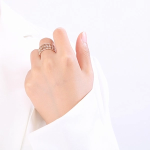 Gros plan d'une bague chaîne ajourée en or rose portée au doigt d'un mannequin