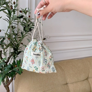Detail of floral drawstring pouch showing linen texture and colorful botanical patterns