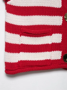 Detail of red and white striped knit top showing texture and golden button accents