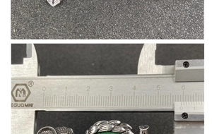 Macro detail of natural green crystal owl brooch measured with a caliper