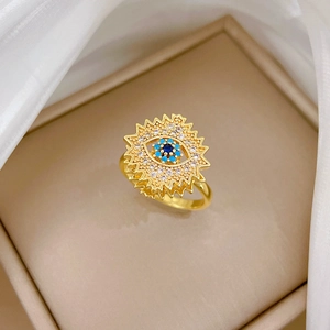 Macro shot of rotating evil eye ring with blue stones and sunburst texture detail