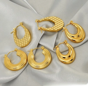 Détails de créoles dorées 18 carats avec textures ondulées et motifs de losanges