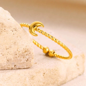 Detailed shot of a gold crescent moon ring with twisted rope texture on a stone