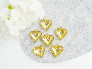 Detail of six gold-plated heart-shaped jewelry pendants with sparkling crystal inlay