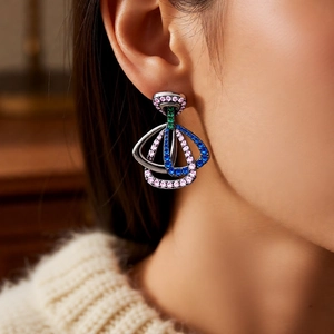Gros plan de boucles d'oreilles vintage avec zircons colorés portées par un mannequin