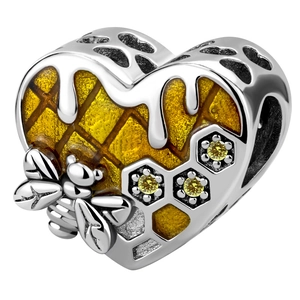 Macro shot of 925 silver heart charm with honeybee, yellow enamel and cubic zirconia