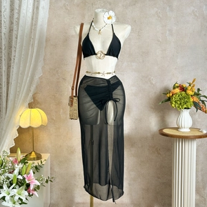 Detail of black 3-piece bikini set with gold buckle and drawstring mesh beach skirt