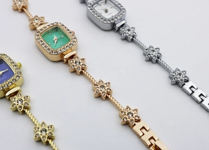 Detailed view of three luxury square quartz watches with rhinestone-encrusted floral bracelets