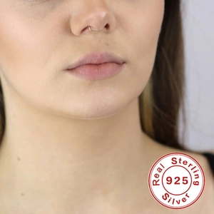 Close-up of 925 sterling silver golden twisted nose ring worn by a professional model