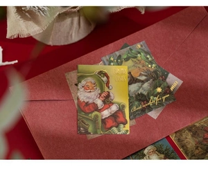 Close-up of vintage Christmas stickers with gold foil details and Santa Claus illustrations