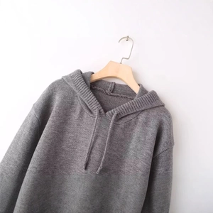 Minimalist loose long sleeve hooded knit sweater in grey color hanging on wooden hanger