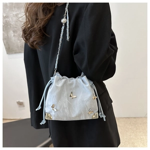 Detail of silver bucket bag with metallic butterfly accents and textured pleats
