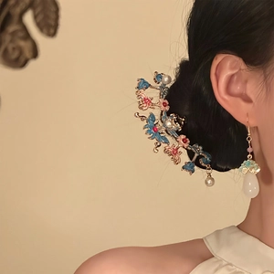 Détail d'une pince à cheveux papillon en émail avec boucles d'oreilles assorties
