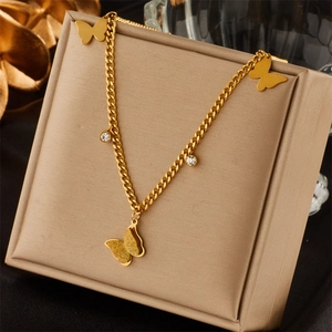 Detailed close-up of golden Cuban chain with matte butterfly pendant and crystal accents