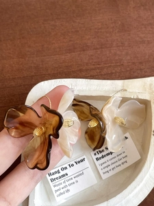 Detailed macro view of amber and cream acrylic flower petals with golden metal center