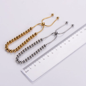 Detailed close-up of adjustable bead bracelets in gold and silver finish with slide clasp