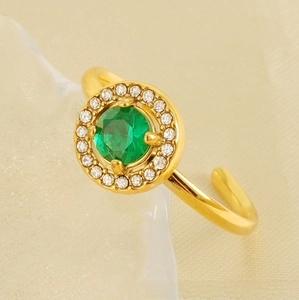 Macro shot of gold double-layer ring featuring a green zircon center and halo diamonds