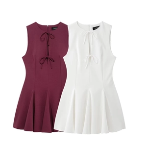 Detailed view of sleeveless mini dress with cutout bow tie and pleated hem texture