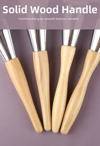 Close-up of four solid wood makeup brush handles with natural grain and silver ferrules