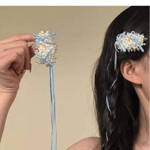 Barrette nœud en velours bleu avec perles et longs rubans élégants en gros plan