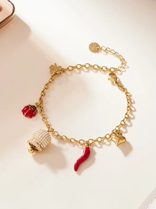 Détail d'un bracelet en acier doré avec breloques coccinelle, cloche, piment et cœur