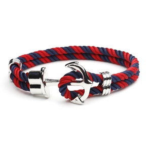 Detail of nautical anchor bracelet with red and blue braided rope and silver metal clasp