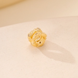 Golden round spacer bead with inlaid zircon crystals and detailed relief craftsmanship