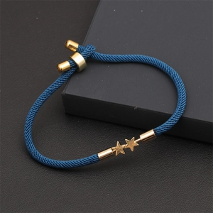 Detail of navy blue braided rope bracelet featuring two golden star charms and adjustable clasp
