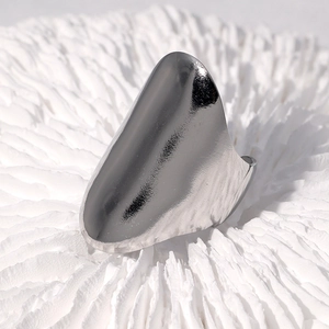 Polished silver stainless steel chunky ring with sharp edges on coral texture