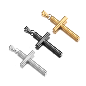 Three minimalist cylindrical cross pendants in gold, black, and silver on white background