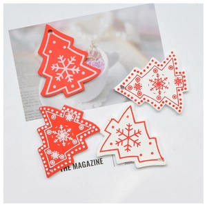 Detail of red and white wooden Christmas tree ornaments with snowflake patterns and twine