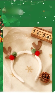 Macro view of Christmas antler headband with white faux fur and red green pom poms