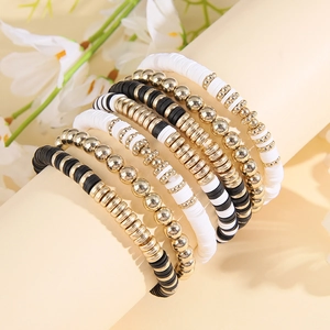 Detail of bohemian heishi bead bracelet set with black, white and gold layered beads