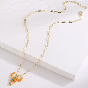 Detail of 18K gold plated bull head pendant necklace with orange and turquoise enamel