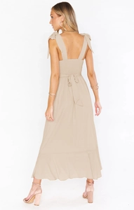 Detail of apricot dress featuring ribbon tie back, elastic smocking, and bow straps