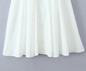 Détail de la jupe plissée blanche en mousseline avec des plis verticaux élégants