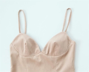 Détail des fines bretelles et de l'encolure d'une robe courte beige dos nu sexy
