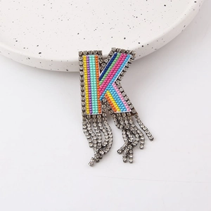 Detailed view of colorful beaded letter K brooch with crystal fringe and rhinestone border