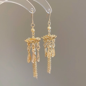 Detailansicht goldener Lotus-Quastenohrringe mit filigraner, hohler Metallverarbeitung