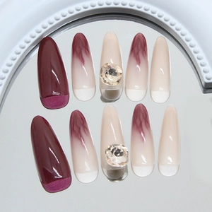 Long almond press-on nails in burgundy with flame marble design and rhinestones