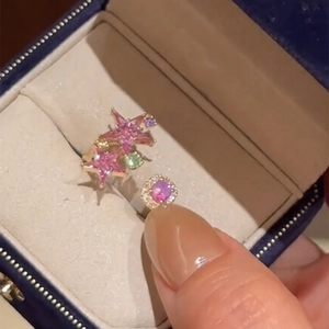 Minimalist open star ring with pink gemstones and colorful zircons on a navy velvet box