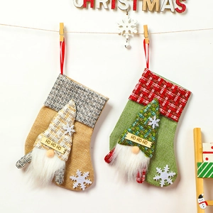 Linen Christmas stockings with gnome doll and 'HO HO HO' sign for holiday tree decoration