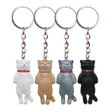 Detailed view of four 3D cartoon cat keychains in white orange grey and black