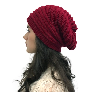 Detailed close-up showing the texture of a wine red thick knitted slouchy beanie hat