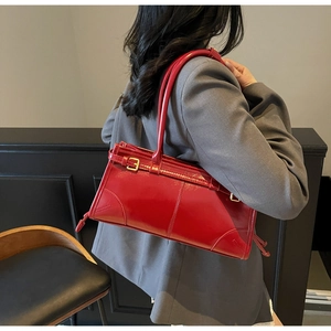 Detail shot of the red patent leather shoulder bag with long handles and geometric design