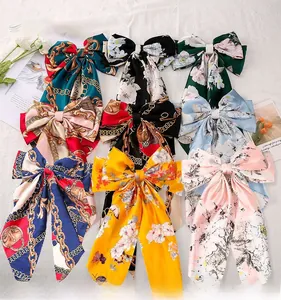 Flat lay of vintage floral print oversized bow hair clips in assorted silk-like fabrics