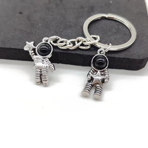 Close-up of vintage alloy astronaut keychain with star pendants and retro metallic texture