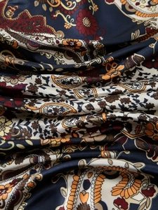 Close-up of premium silk scarf with vintage paisley pattern and satin finish texture
