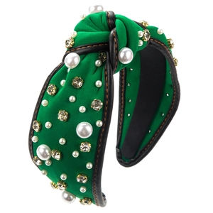 Détail du serre-tête noué vert orné de perles blanches et de strass brillants