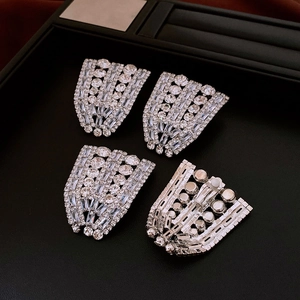 Detailed close-up of fan-shaped geometric earrings with high-density zircon stones